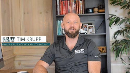 Tim Krupp, owner of Krupp Moving and Storage, speaking about marketing strategies, with a bookshelf in the background, wearing a branded polo shirt.